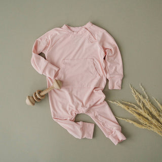  A baby wearing a soft and comfortable organic bamboo romper in a beautiful rose color.