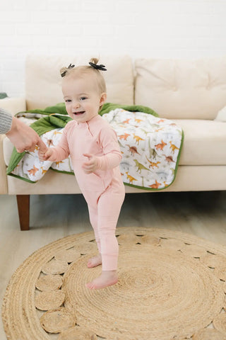  A baby wearing a soft and comfortable organic bamboo romper in a beautiful rose color.